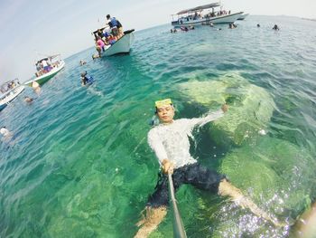 Fish-eye lens shot of man swimming in sea