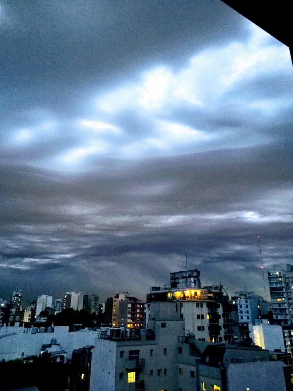 HIGH ANGLE VIEW OF ILLUMINATED CITY AGAINST SKY