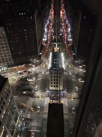 High angle view of illuminated city street and buildings at night