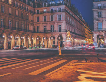 View of city street and buildings at night