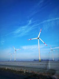 Low angle view of windmill on field against sky