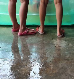 Low section of women standing on wet floor