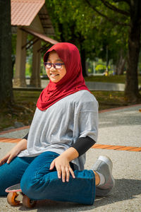 Young girl wearing hijab is ont he skateboard at the park.