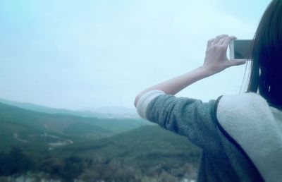 Woman standing on mountain against sky