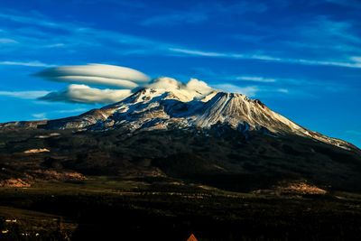 Scenic view of mountains against blue sky