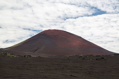 View of desert against cloudy sky