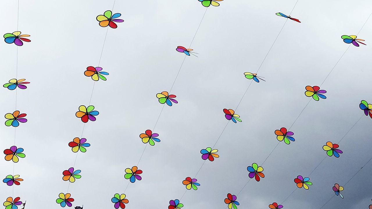 LOW ANGLE VIEW OF MULTI COLORED BALLOONS IN SKY