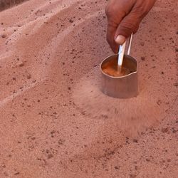 High angle view of person holding ice cream on sand