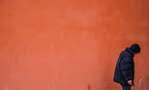 Man standing against orange wall