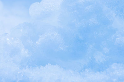 Full frame shot of snowflakes on blue sky