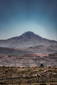 Scenic view of landscape and mountains against clear sky