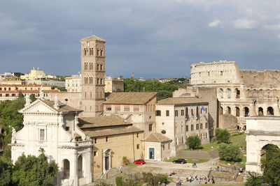 Buildings in city against cloudy sky