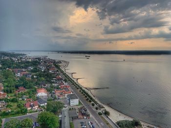 High angle view of sea and buildings against sky during sunset