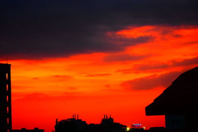 Silhouette city against orange sky