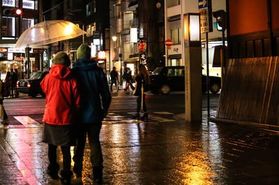 Man standing on city street at night