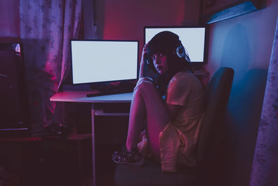 Woman sitting on table at home