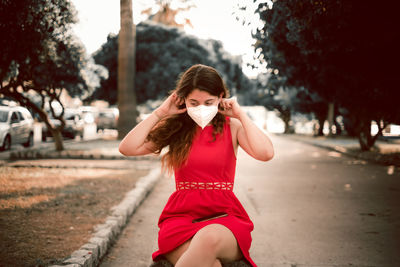 Portrait of young woman on road in city