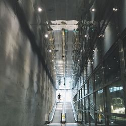 Full length of woman walking on illuminated walkway