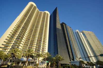 Low angle view of modern buildings against clear blue sky