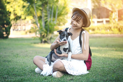 Portrait of a smiling young woman sitting at park