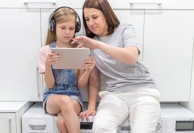 Young woman using mobile phone while sitting on sofa at home