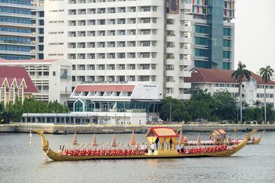 Boats in river by buildings in city