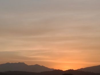 Scenic view of silhouette mountains against sky at sunset