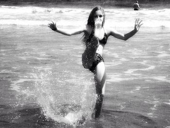 Full length of woman jumping in water