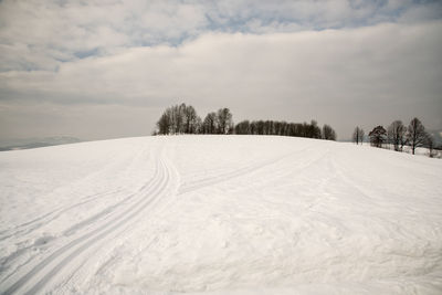 Snow covered field against sky