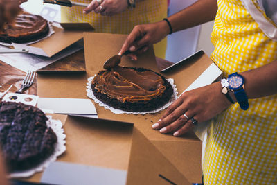 Midsection of people preparing food on table