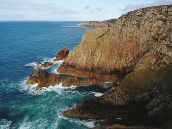 Rock formation in sea against sky