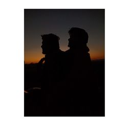 Silhouette couple standing at sunset