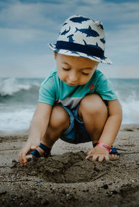 Boy playing with sand at beach