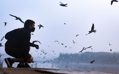 Low angle view of man flying against sky