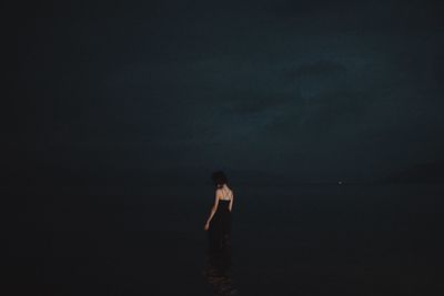 Woman standing on beach against sky