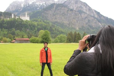 Rear view of woman looking at grassy field