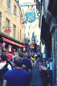 Rear view of people walking on street in city