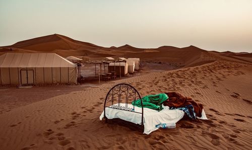 Tent on sand dune in desert against sky