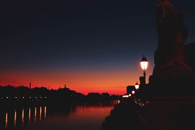 Silhouette buildings against sky at dusk