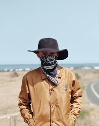 Midsection of man wearing hat against clear sky