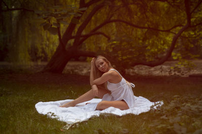 Portrait of a smiling young woman sitting on land