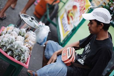 Young man holding food at market