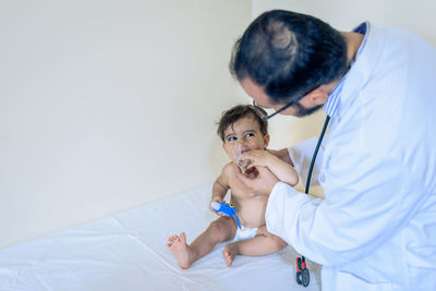 Doctor observing a one-year-old baby