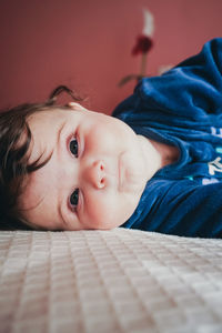 Portrait of cute baby girl on bed at home