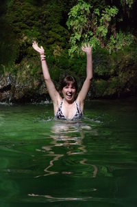 Portrait of cheerful woman swimming in lake