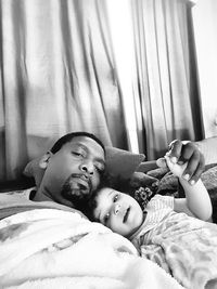 Father with baby on bed at home