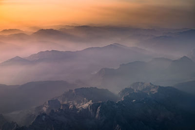 Scenic view of mountains against orange sky