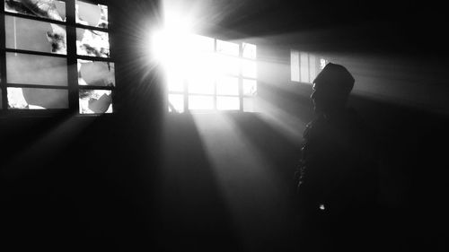 Rear view of sunlight streaming through silhouette window