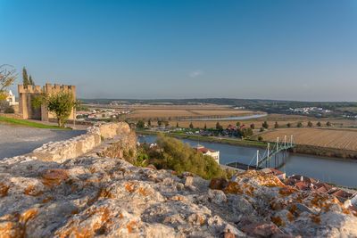 Scenic view of river by city against clear sky