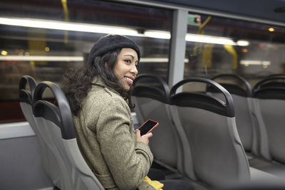 Woman looking at camera while sitting in bus